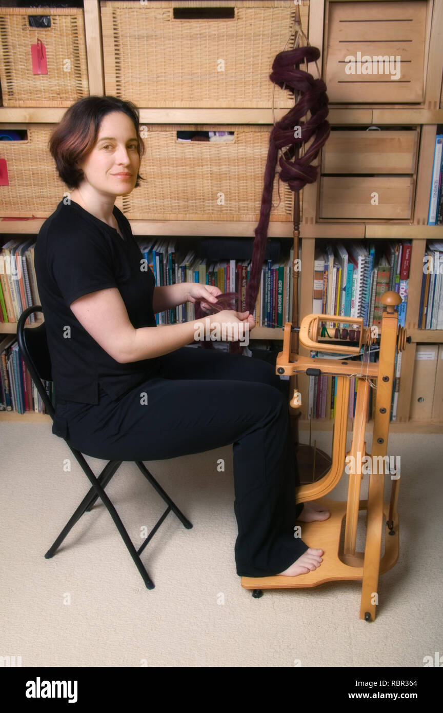 Frau Spinnen auf einem Schacht unvergleichliche Single tritt Aufrecht Spinnrad (Schloss-Stil), mit Alpaka nach oben Faser. Stockfoto