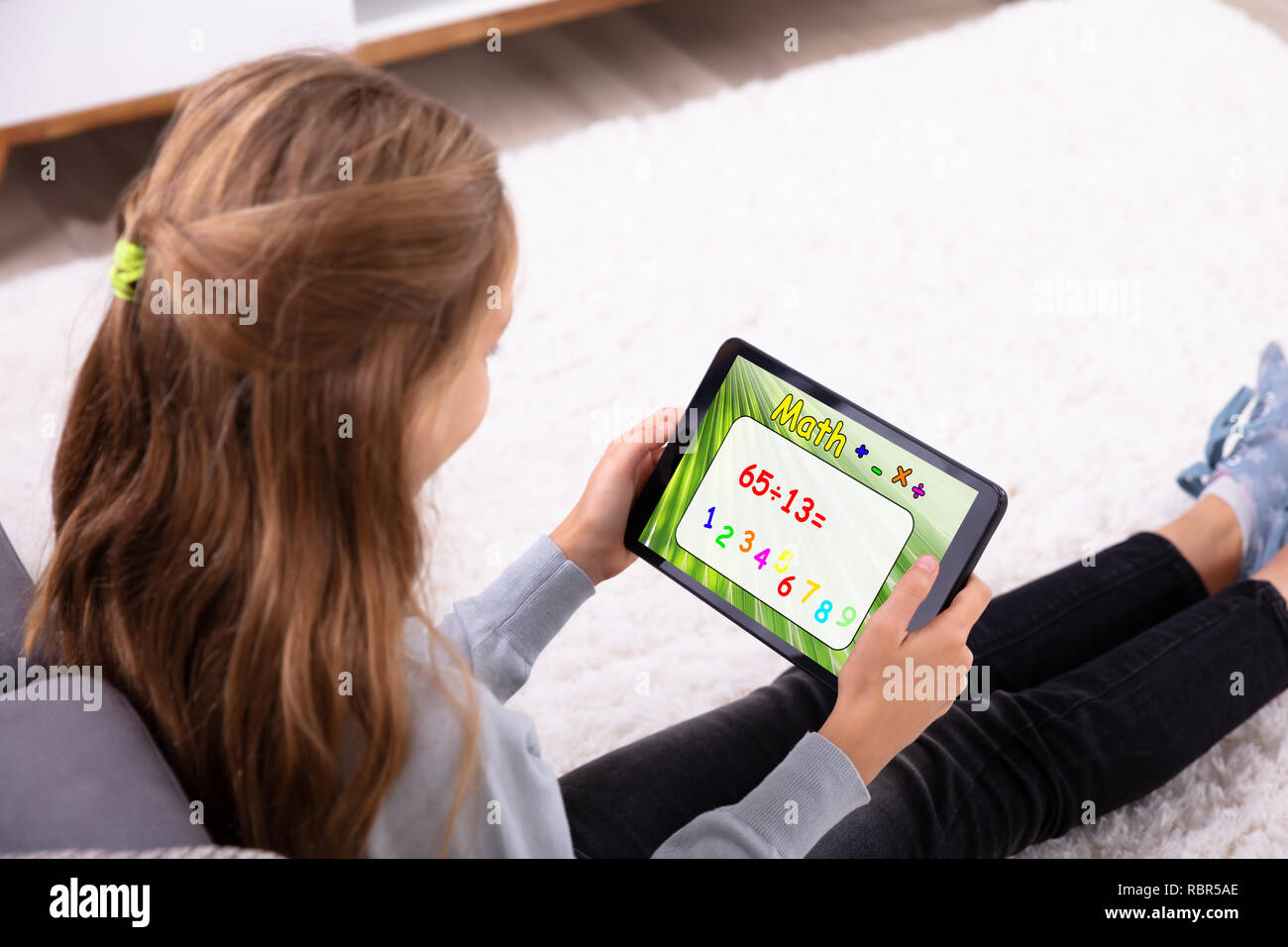 Mädchen mit digitalen Tablet für die Lösung der Mathe zu Hause Stockfoto