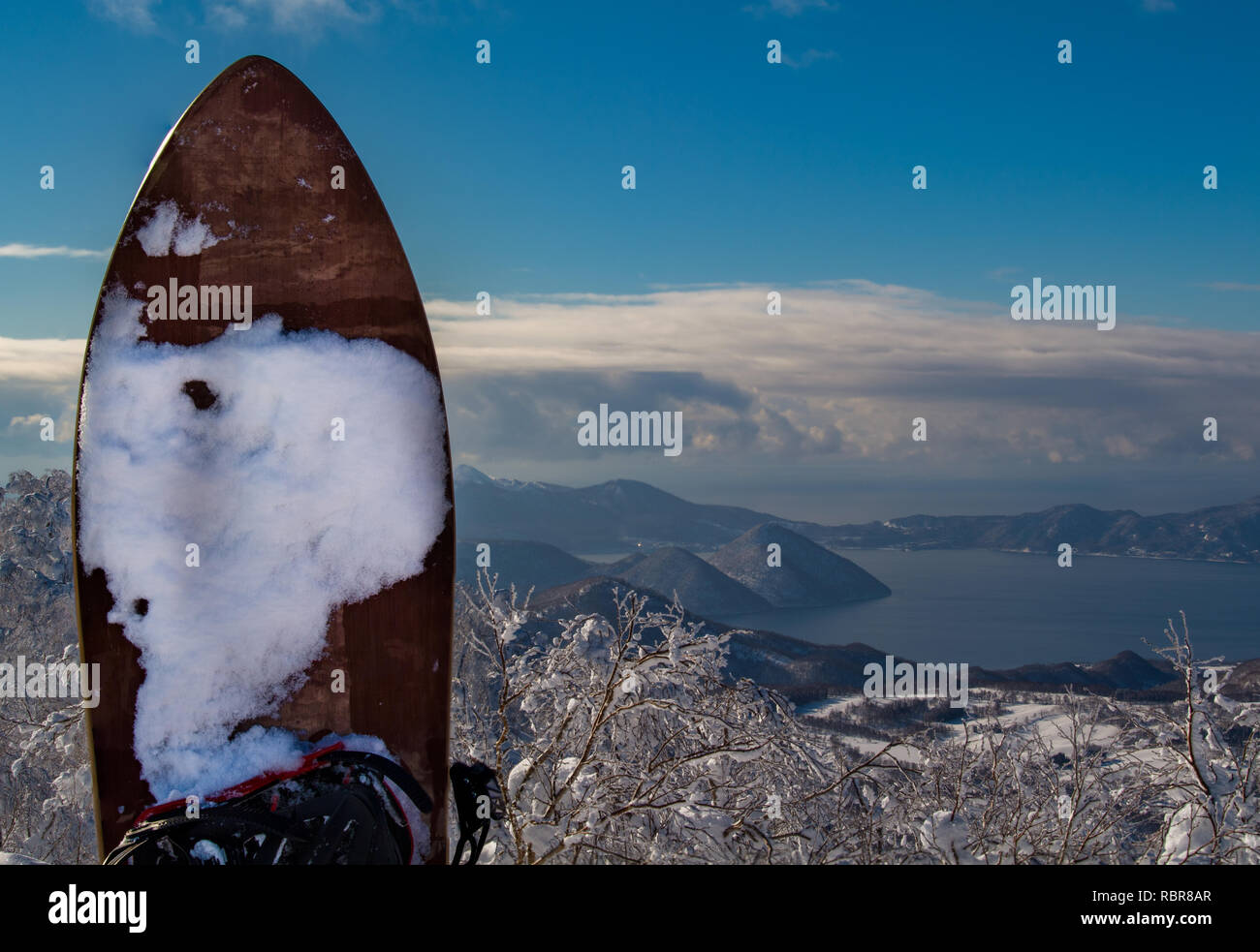 Ein Gentem Snowsurf Board im Vordergrund mit See Toya im Hintergrund Rusutsu Ski Resort, Hokkaido, Japan. Stockfoto