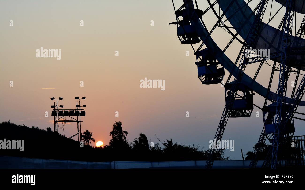 Schönen Sonnenuntergang mit Bäumen, Light Boards und Riesenrad. Stockfoto