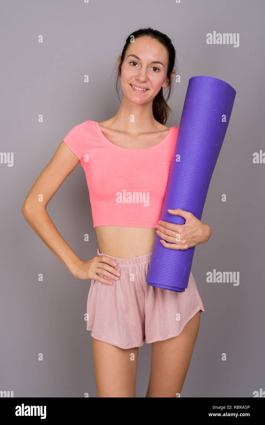 Junge schöne Frau bereit für gym Holding Yoga Matte Stockfoto