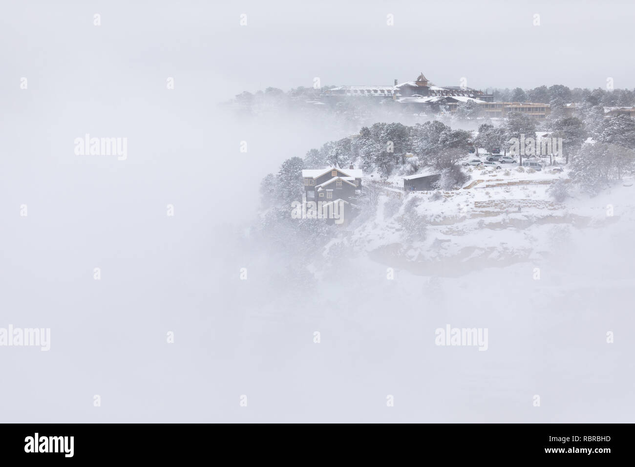 Kolb Studio und das El Tovar Hotel am Rand des Grand Canyon voller Wolken und Nebel im Grand Canyon National Park, Arizona Stockfoto