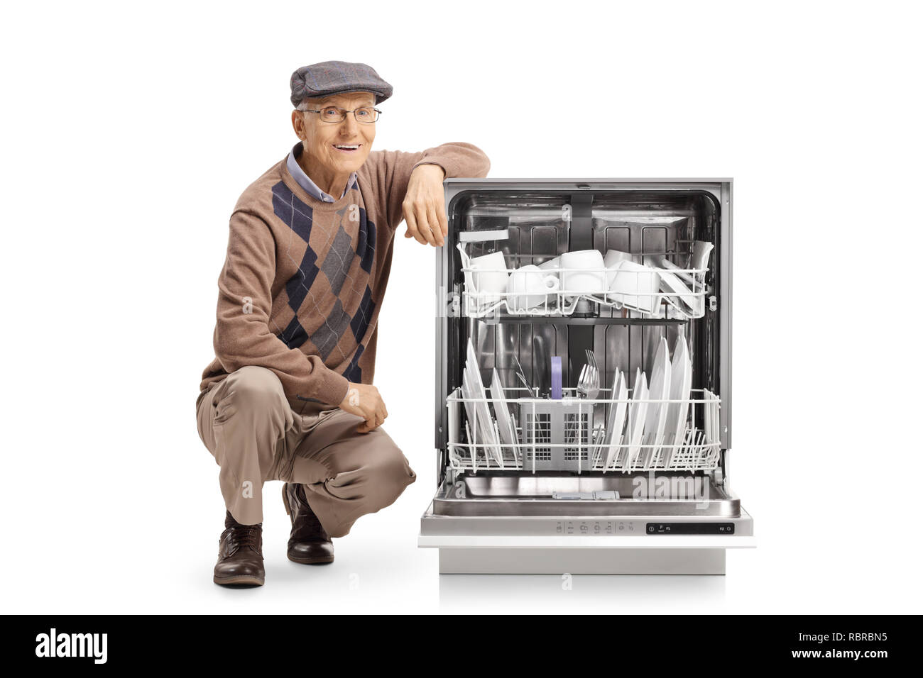 Ältere Mann neben einem beladenen Spülmaschine auf weißem Hintergrund kniend Stockfoto