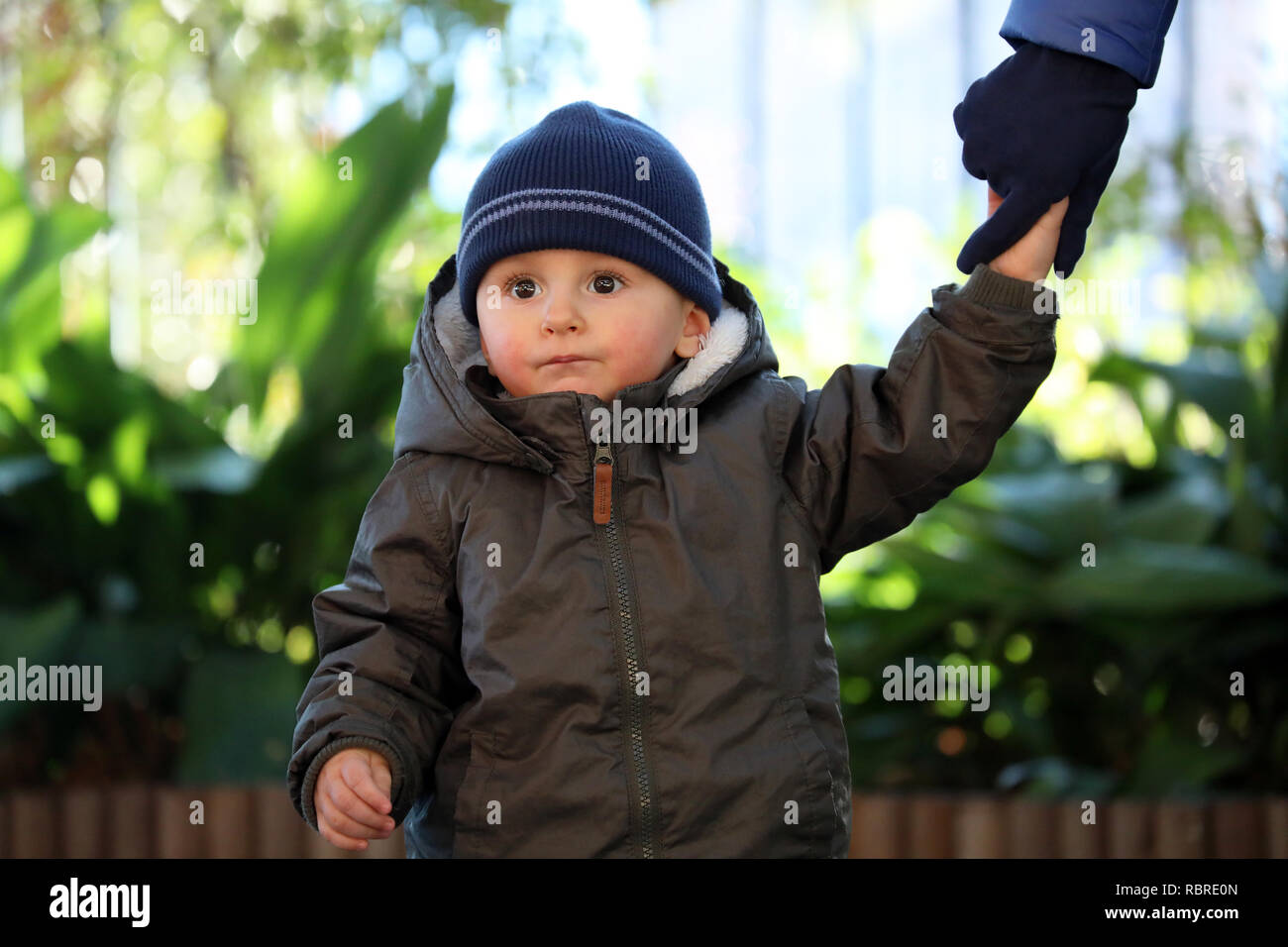 Close Up Portrait von Cute Baby Boy trägt einen blauen und grünen Hut Stricken Winter Winter Parka Stockfoto