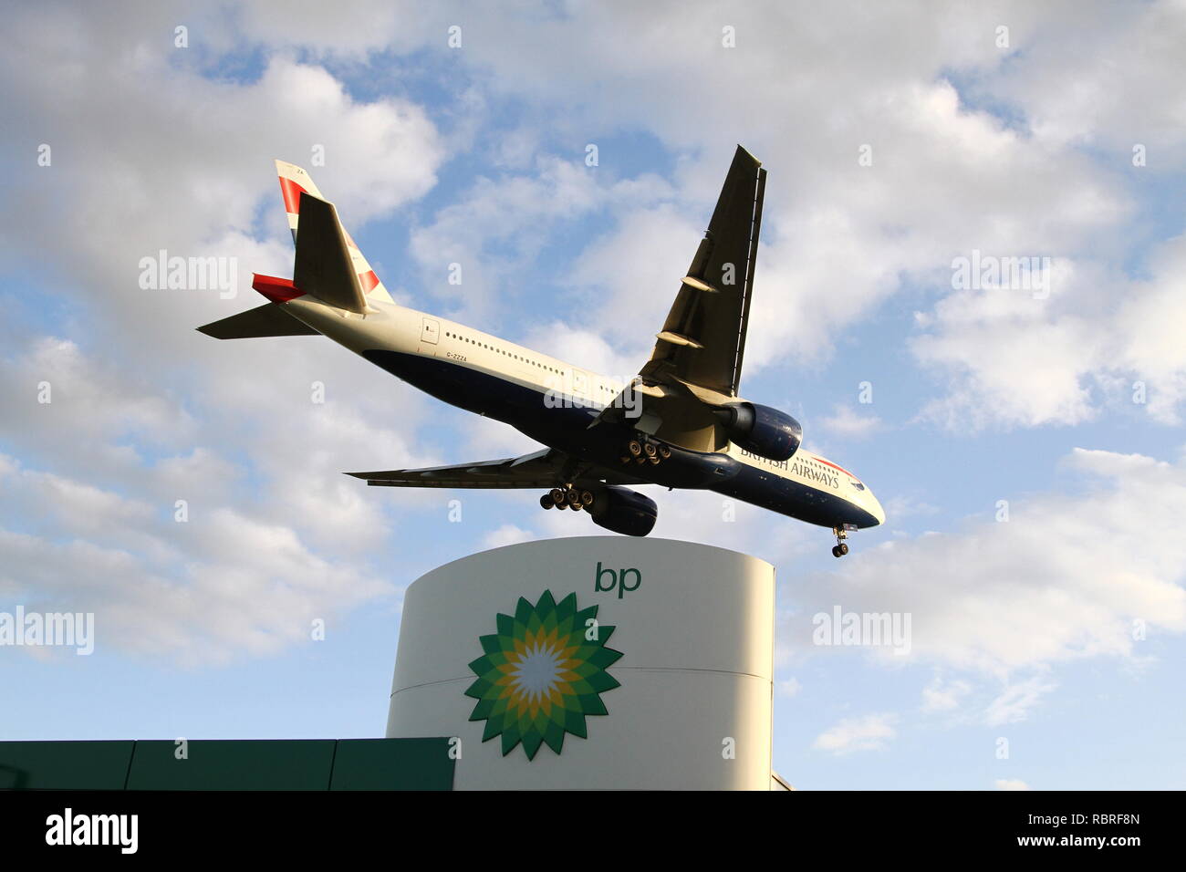 Einen British Airways Verkehrsflugzeug absteigend am Flughafen Heathrow in London über eine BP-Tankstelle zu landen. Britische Unternehmen. British Airways ist Teil der [DIAG] internationale Airline Group und British Petroleum PLC sind an der London Stock Exchange gelistet und im FTSE 100-Index. Stockfoto