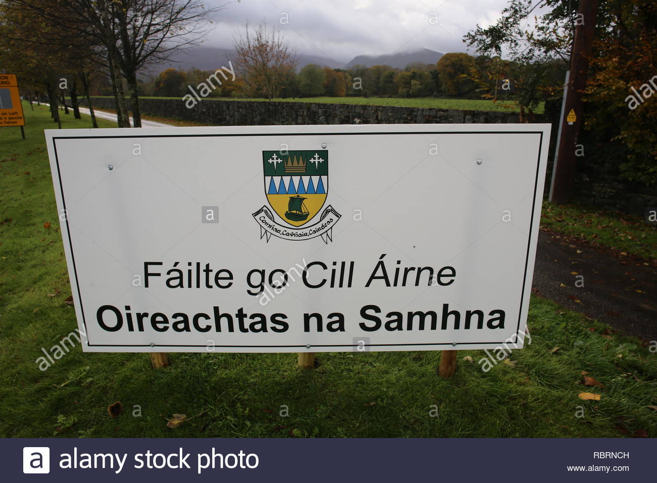 Ein Zeichen in Irisch und Englisch außerhalb von Killarney, County Kerry, Besucher auf eine irische Sprache Festival. Stockfoto
