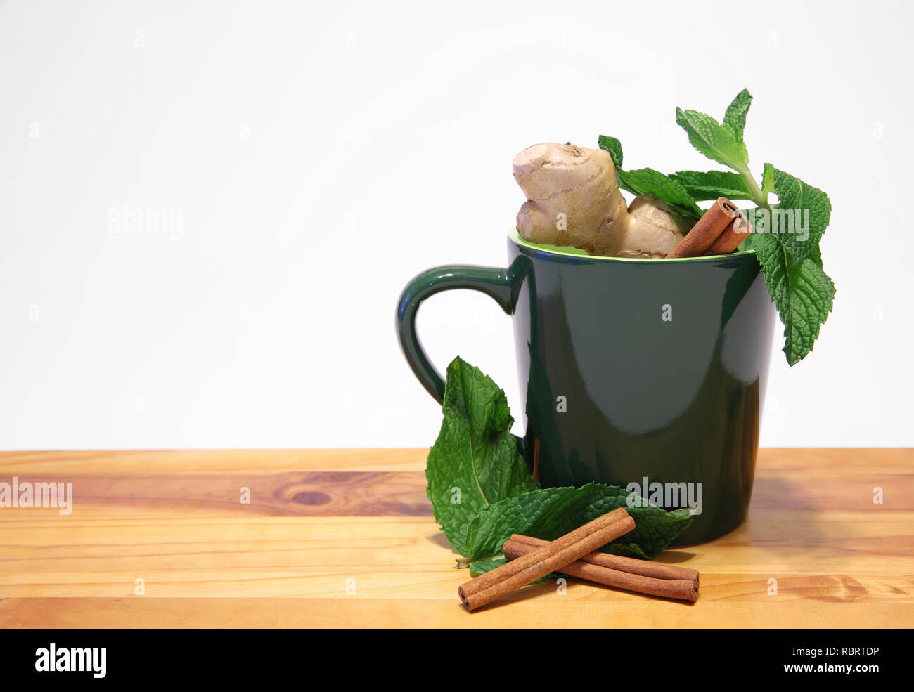 Grüne Tasse mit natürliche pflanzliche Inhaltsstoffe auf weißem Hintergrund Stockfoto