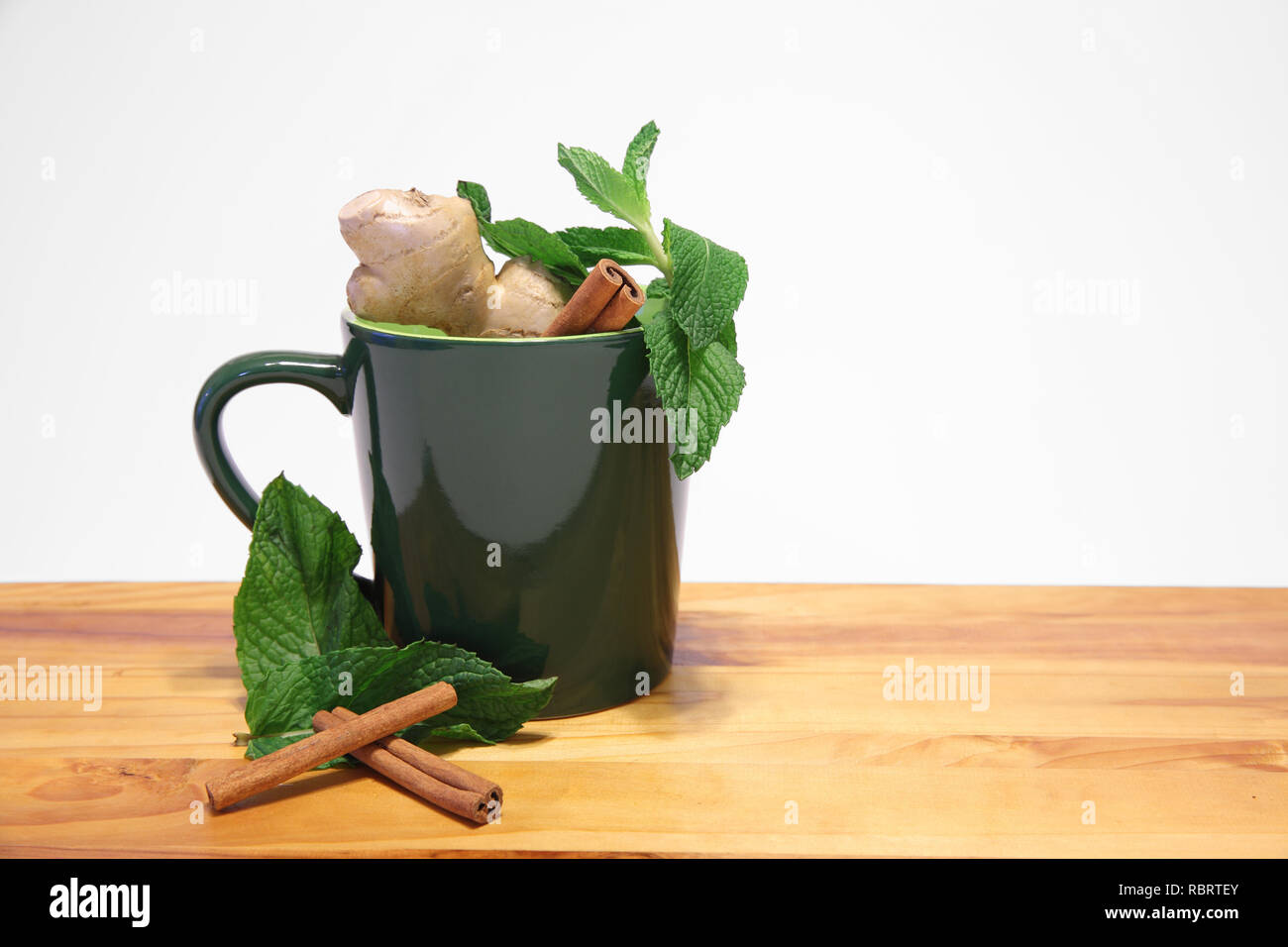 Grüne Tasse mit natürliche pflanzliche Inhaltsstoffe auf weißem Hintergrund Stockfoto