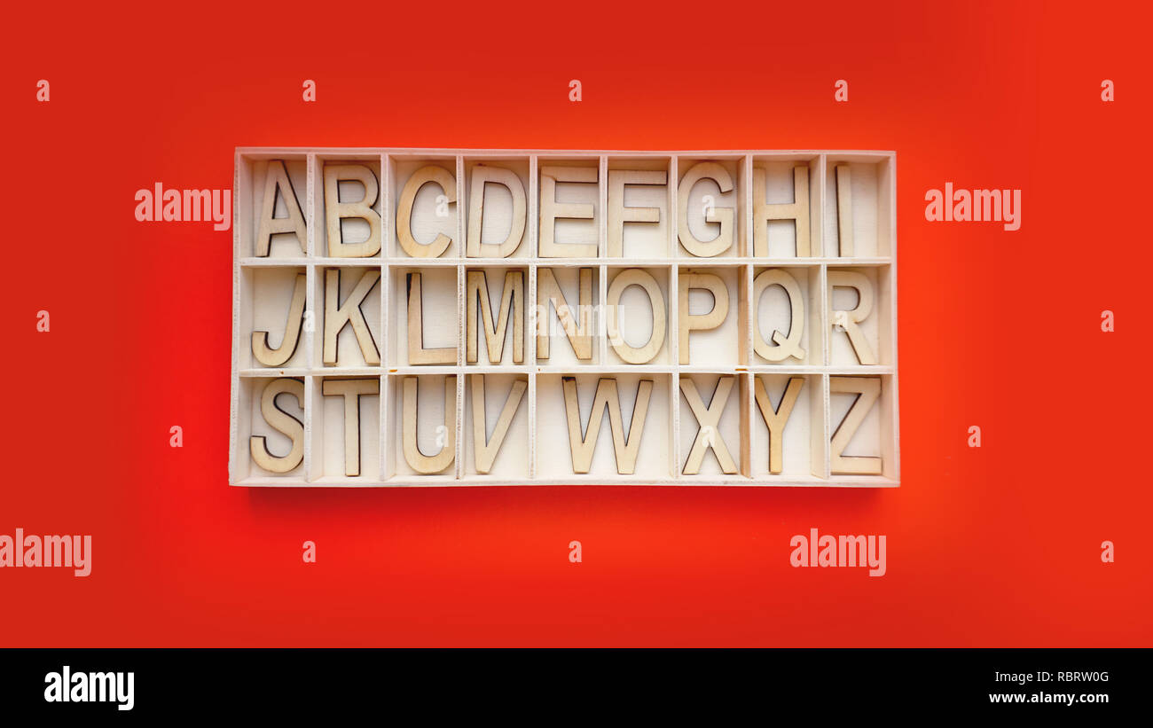 Holz- alphabet Blöcke mit Buchstaben-Box auf einem roten Hintergrund. Konzept der Englisch lernen Stockfoto