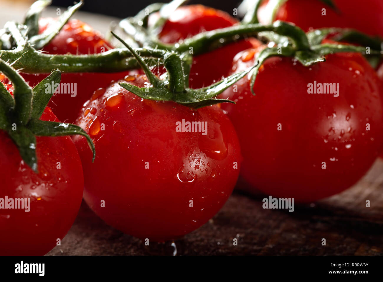 Frische Reihe Cherry Tomaten mit Wassertropfen - Nähe zu sehen. Stockfoto