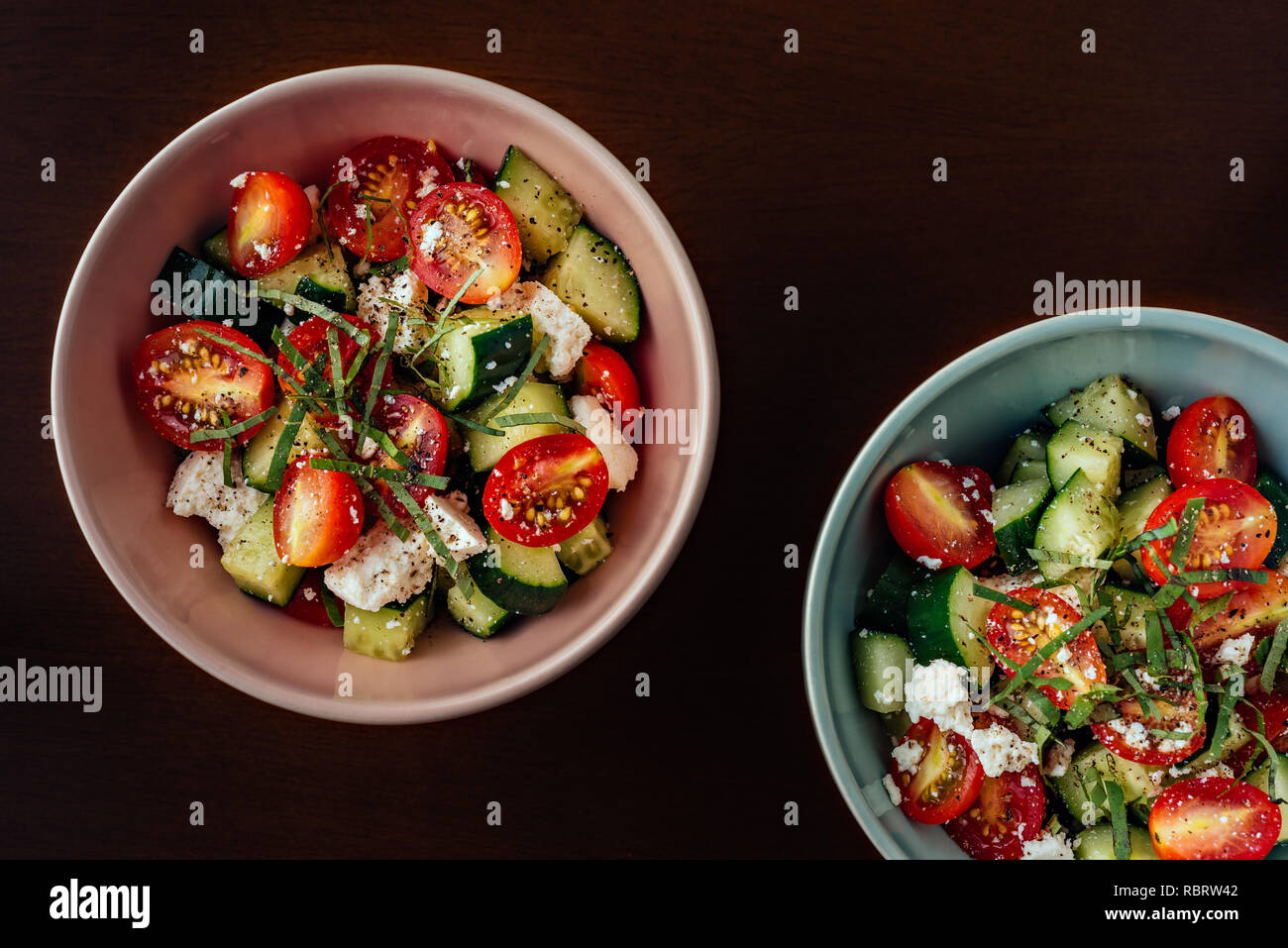 Keramik Schalen mediterraner Griechischer Salat mit Tomaten, Gurken, Schafskäse, Olivenöl extra vergine und schwarzer Pfeffer Stockfoto