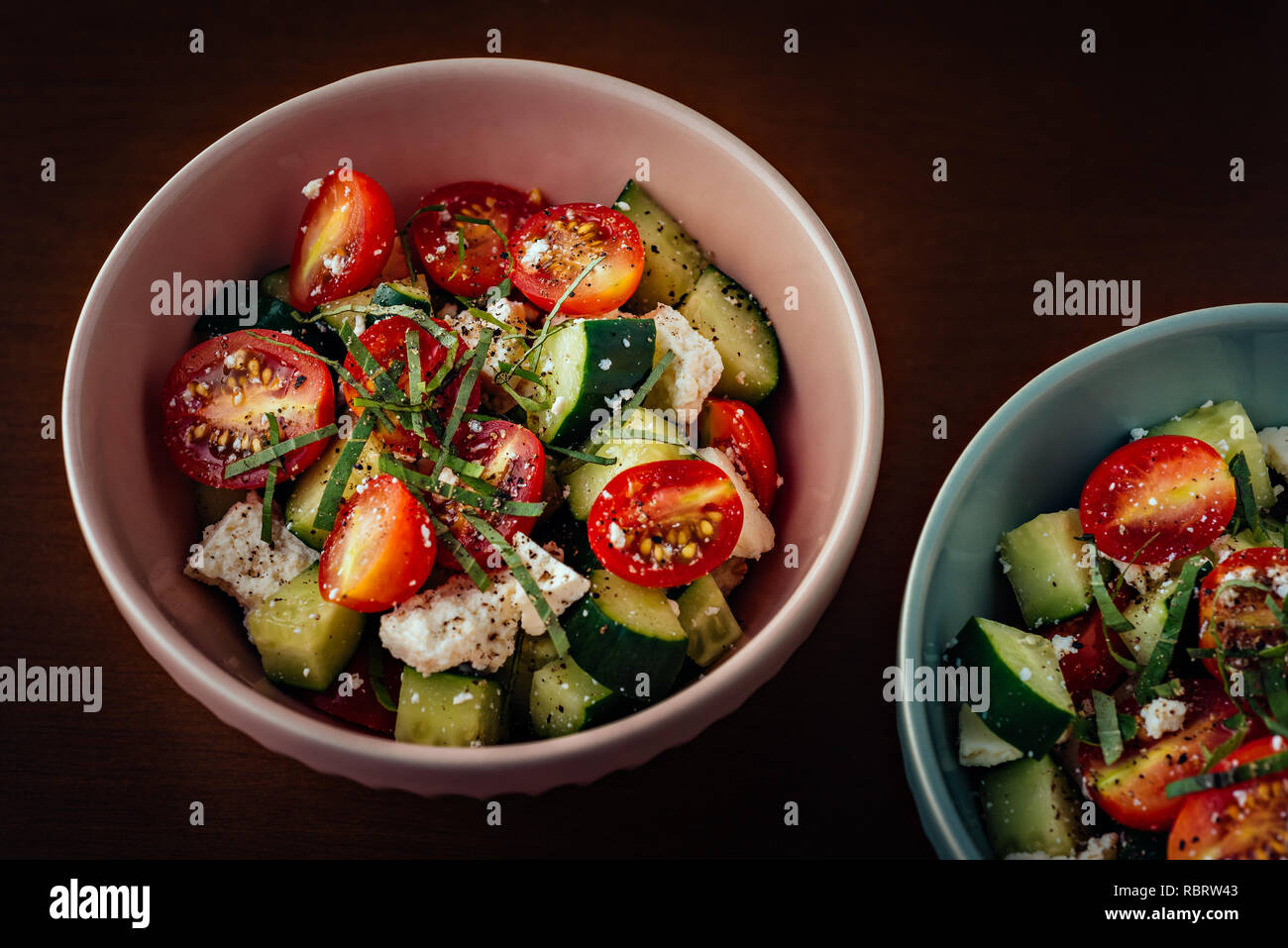 Keramik Schalen mediterraner Griechischer Salat mit Tomaten, Gurken, Schafskäse, Olivenöl extra vergine und schwarzer Pfeffer Stockfoto