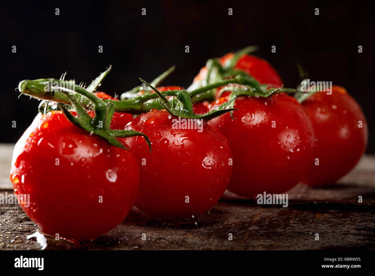 Frische Reihe Cherry Tomaten mit Wassertropfen - Nähe zu sehen. Stockfoto
