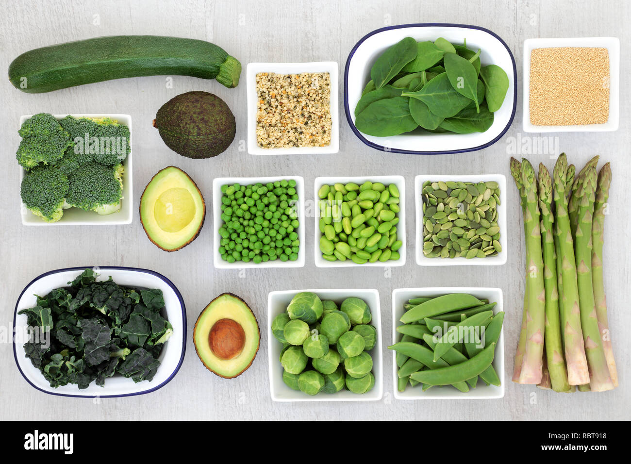 Protein Pflanzenschutz Auswahl an Speisen für eine gesunde Ernährung mit Samen, amaranth Getreide und frische grüne Gemüse auf rustikalem Holz Hintergrund. Stockfoto