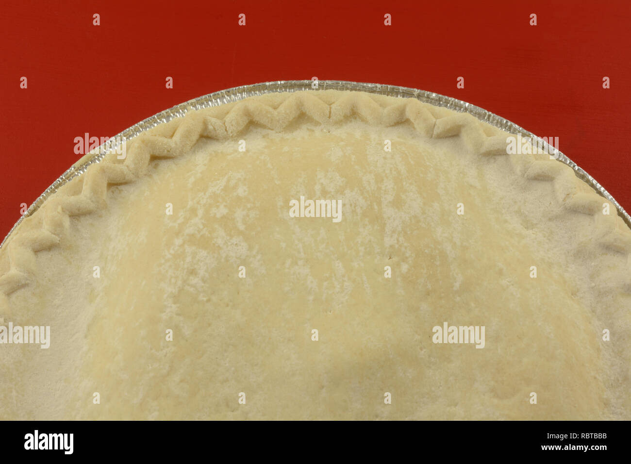 Nahaufnahme von Ungekochten frozen Apple Pie auf rotem Hintergrund Stockfoto