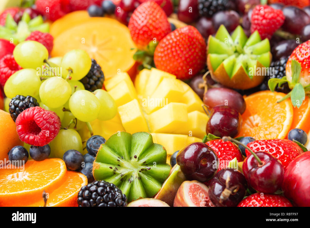 Gesunde Frucht Hintergrund mit Erdbeeren Himbeeren orangen Pflaumen Äpfel gefüllt, Kiwis, Weintrauben, Heidelbeeren mango Kaki Ananas Stockfoto