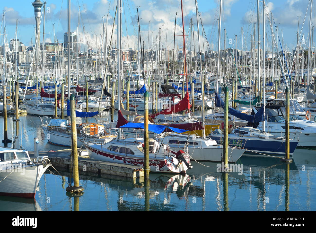 Helle Farben der Boote und ihre Leinwand deckt in der Westhaven Marina mit Auckland City Center im Hintergrund. Stockfoto