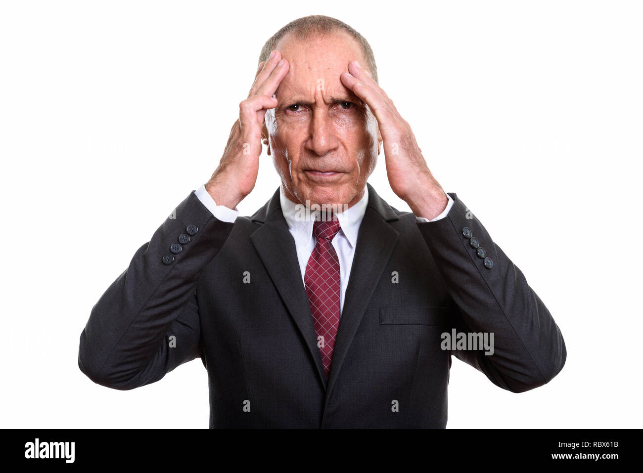 Wütend älterer Geschäftsmann in Kopfschmerzen vor weißem Hintergrund Stockfoto