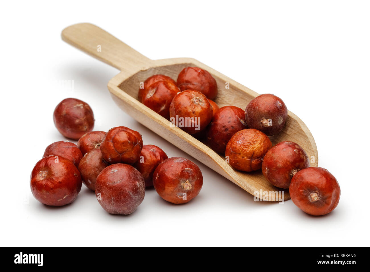 Getrocknete Wacholderbeeren in eine hölzerne Schaufel auf weißem Hintergrund Stockfoto