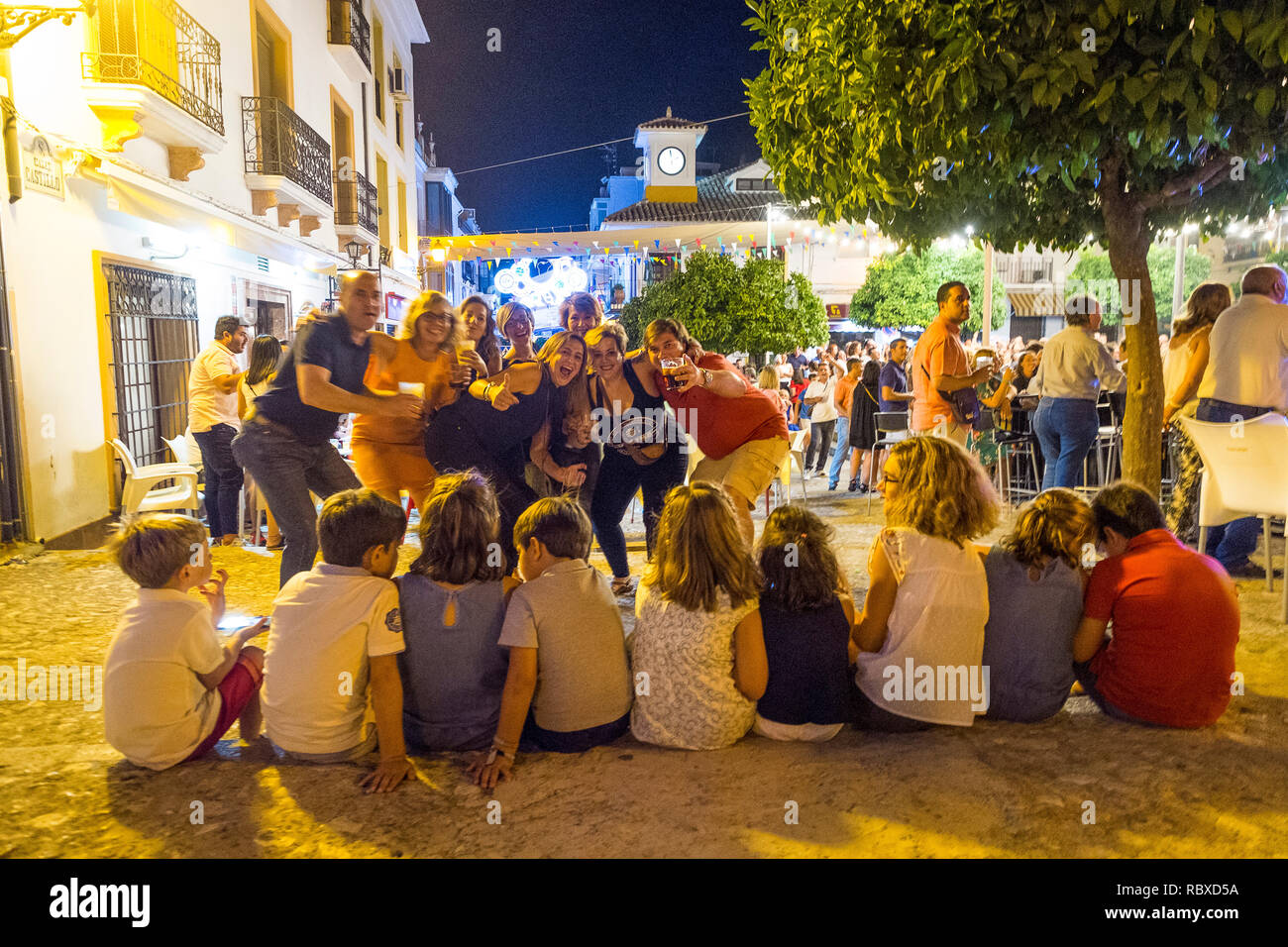 Eltern feiern bei einer Fiesta, während alle ihre kleinen Kinder um 2 Uhr morgens am Telefon sind. Plaza Espana, Carcabuey, Andalusien. Spanien Stockfoto