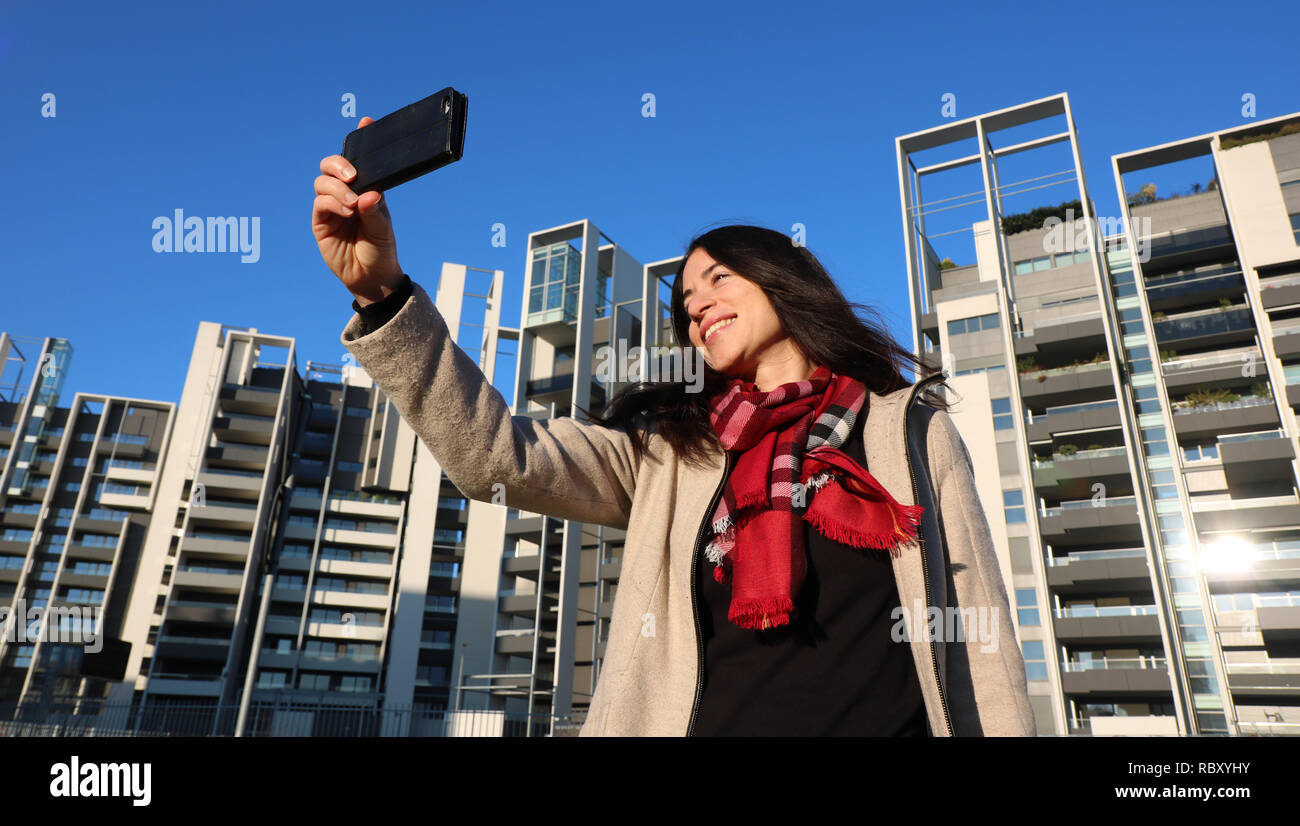 Elegante Frau outdoor das Spielen mit Ihrem Mobiltelefon Stockfoto