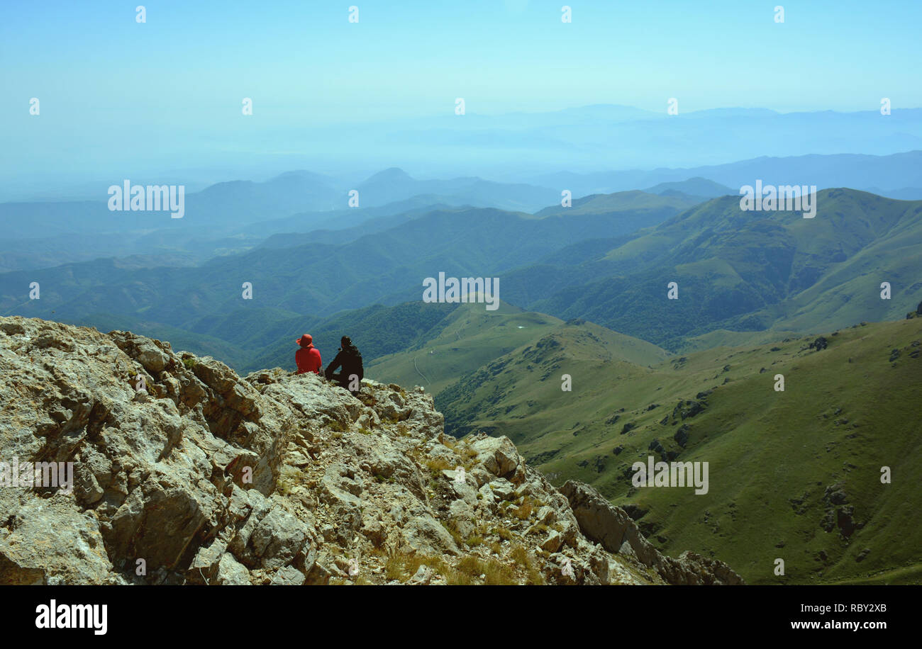 Gerne Reisende genießen den Blick auf den Berg. Wanderer Klettern in Fels. Wanderer auf dem Gipfel eines Berges und genießen den Blick auf das Tal. Stockfoto
