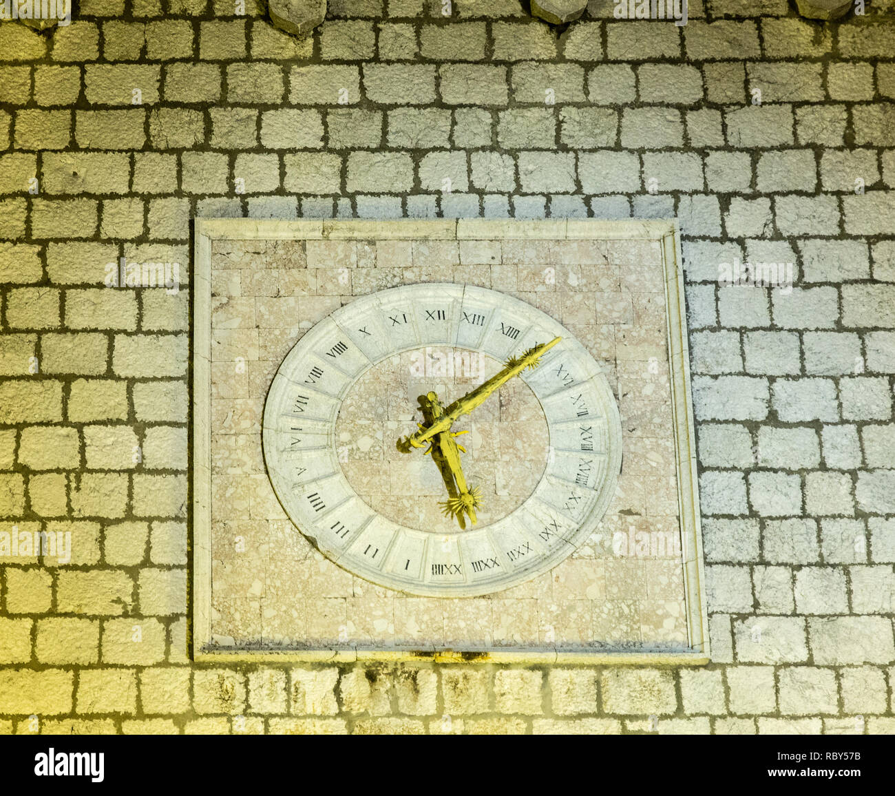 16 Uhr mit goldenen Händen und die römische Ziffer auf der Mauer des Rathauses in der Nacht. Krk, Kroatien Stockfoto