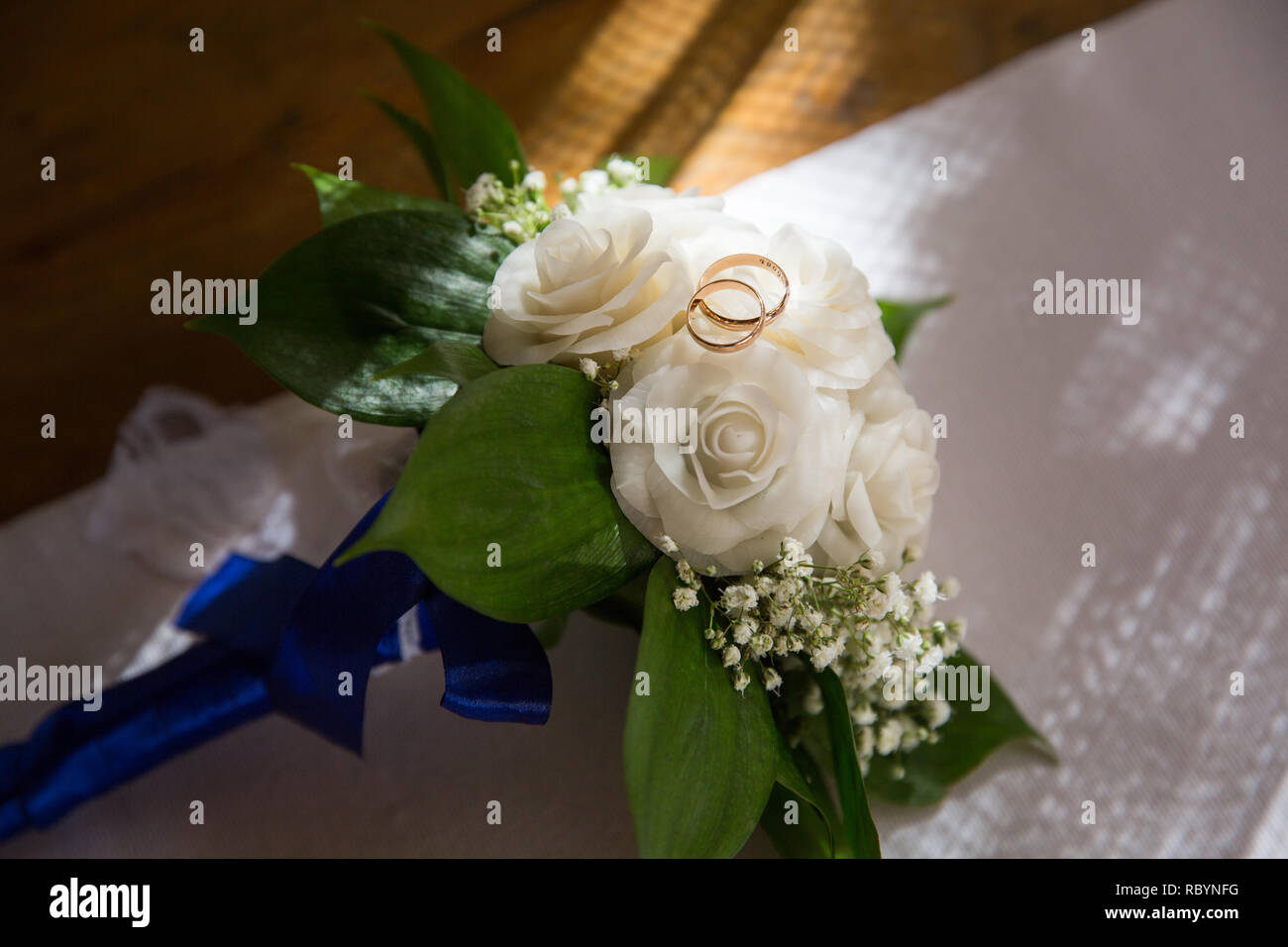 Ein paar Hochzeit Gold Ringe auf einem Bouquet von weißen Blumen Stockfoto