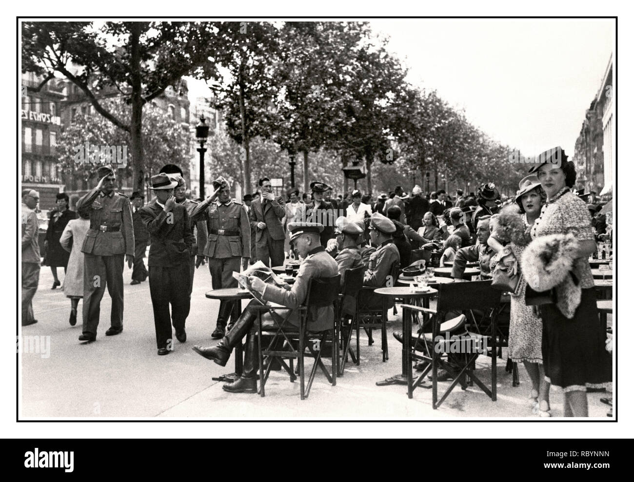1940 PARISER CAFÉ NAZI-DEUTSCHLAND-BESETZUNG BOULEVARD FRANKREICH Deutsche Offiziere der Nazi-Wehrmacht sitzen in einem Boulevard-Café auf einer Straße im Zentrum von Paris, vorbei an deutschen Soldaten grüßen die sitzenden Offiziere mit Pariser, die ihre täglichen Geschäfte machen. Paris, Frankreich Juli 1940 Stockfoto
