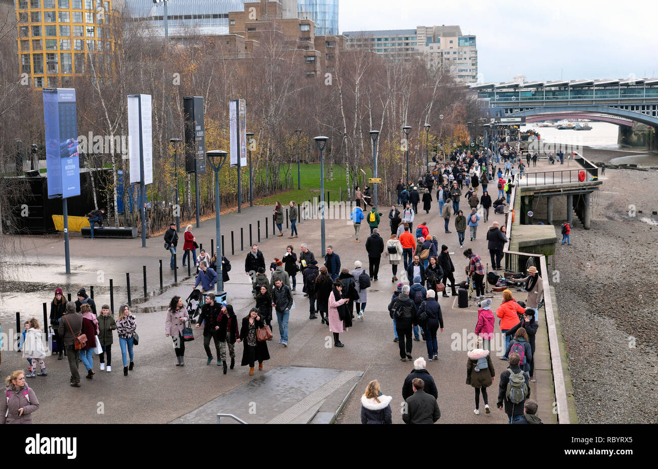 Touristen außerhalb der Tate Modern Art Gallery wandern entlang der Flussufer Bankside der Themse im Süden Londons im Winter UK KATHY DEWITT Stockfoto