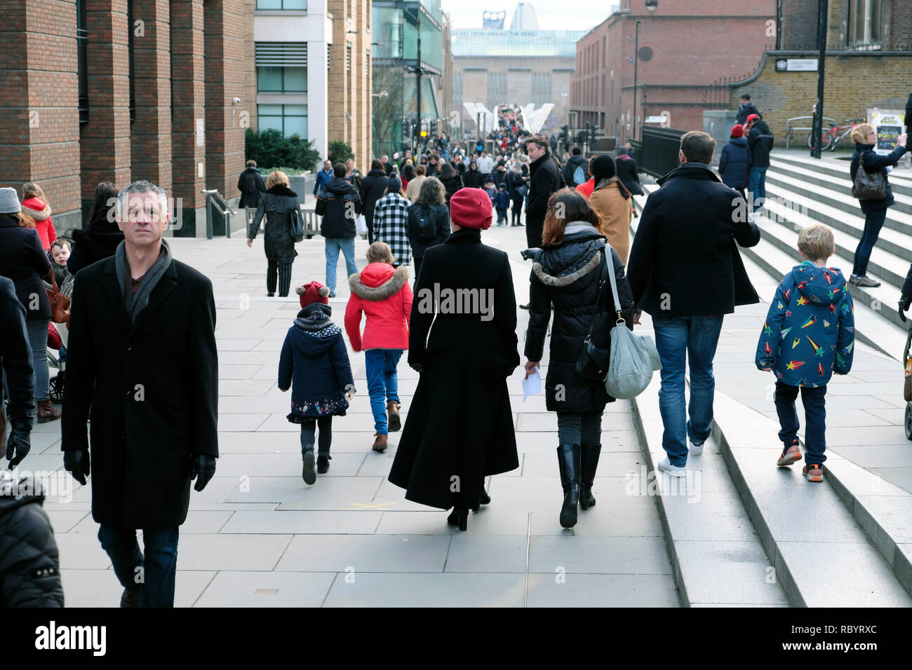 Blick auf Menschen, die im Dezember von St. Pauls zur Millennium Bridge und Tate Modern Art Gallery in der City of London gehen Stockfoto