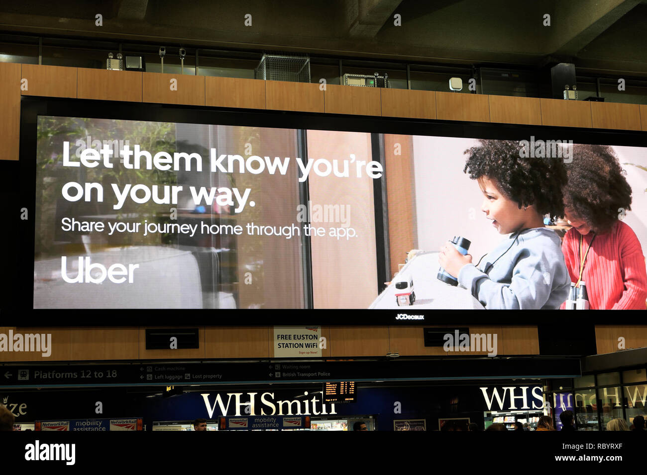 Uber taxi elektronische Werbung Plakatwerbung das Uber App für Mobiltelefone in Euston Bahnhofshalle in London England UK KATHY DEWITT Stockfoto