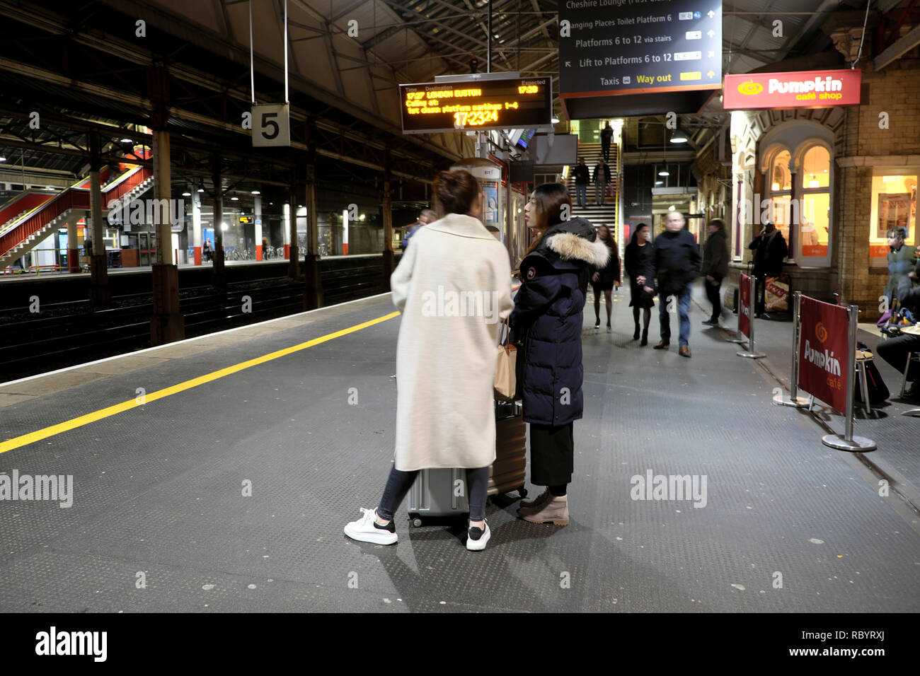 Hintere Rückseite der Passagiere Frau auf der Plattform in Crewe Bahnhof warten auf eine Jungfrau Zug nach London UK KATHY DEWITT Stockfoto