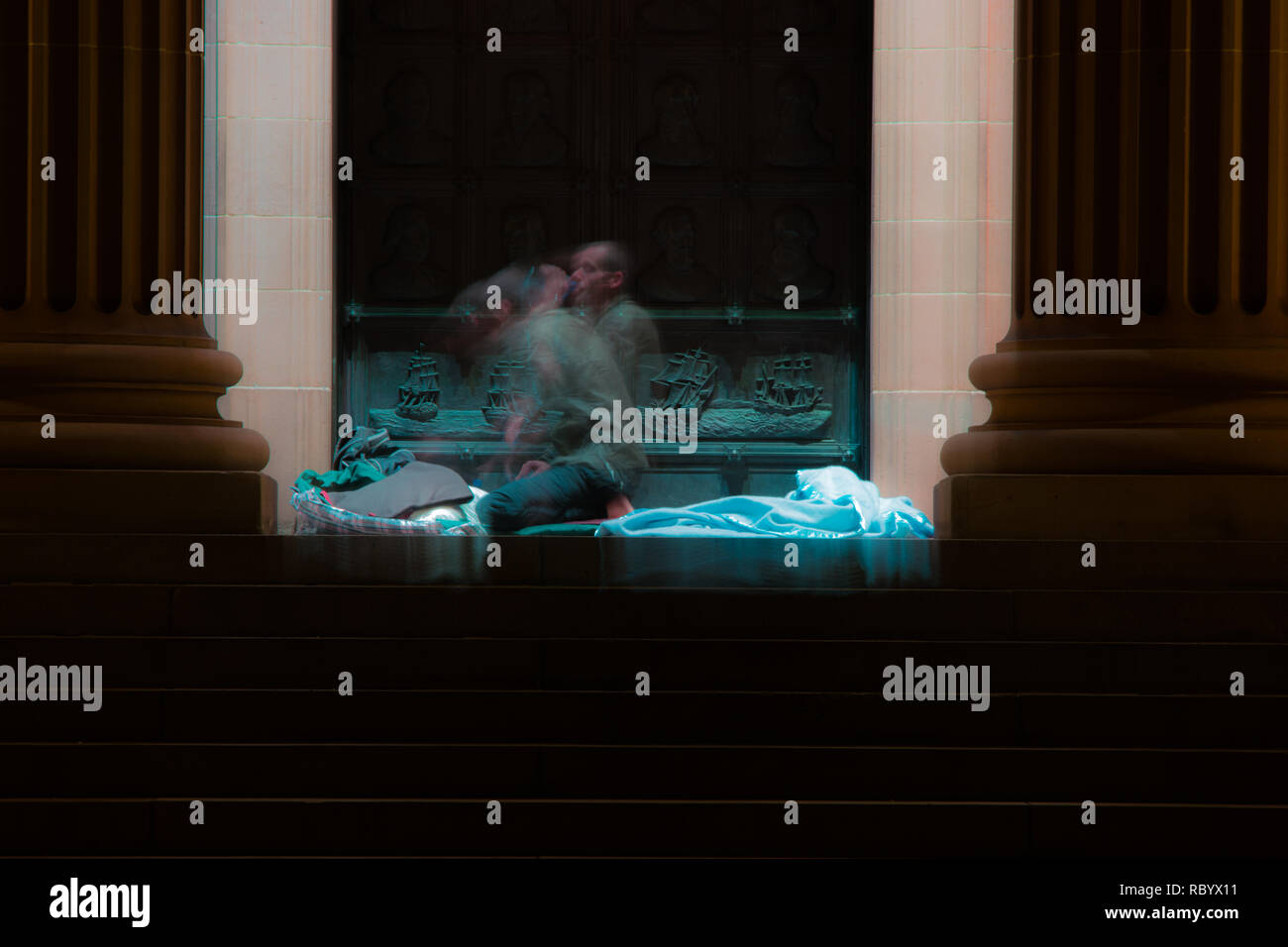 Ein obdachloser Mann weckt Früh am Morgen auf den Schritten einer Bibliothek Stockfoto