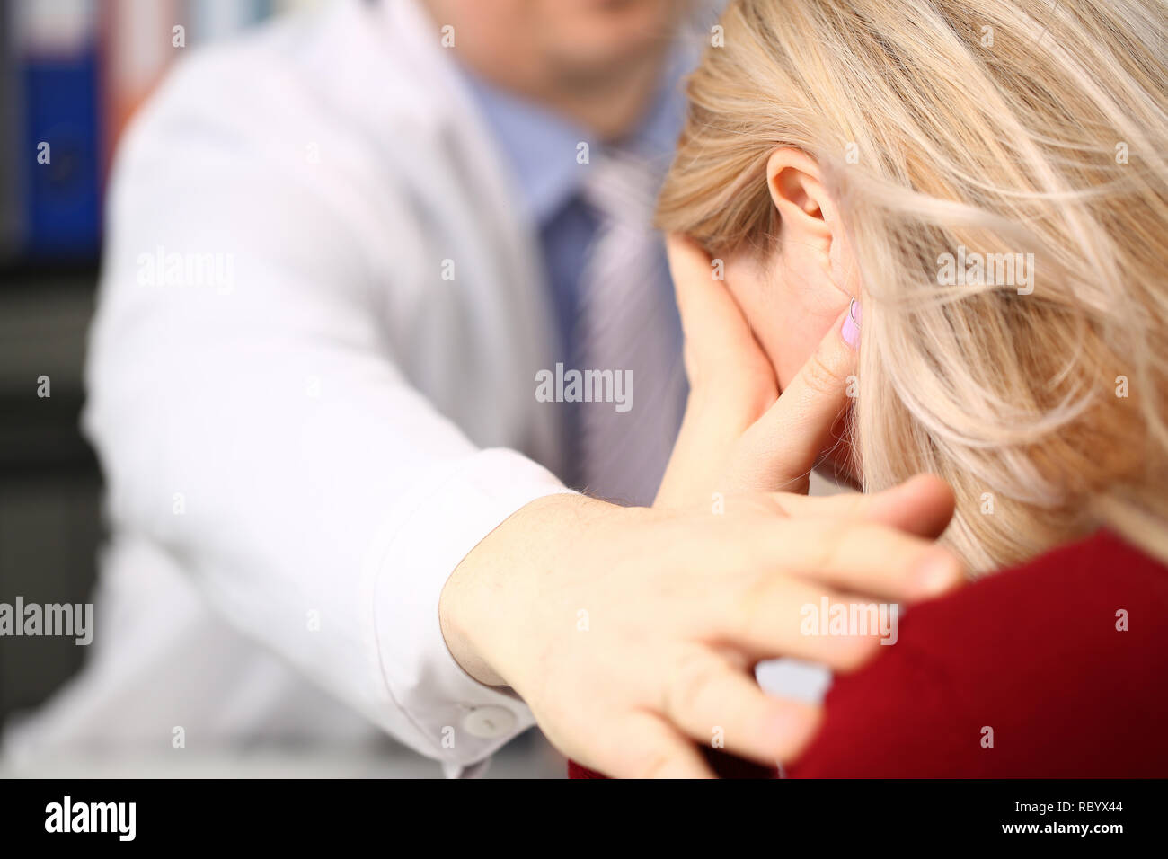 Junge männliche Arzt hält kranken Patienten von Hand Stockfoto