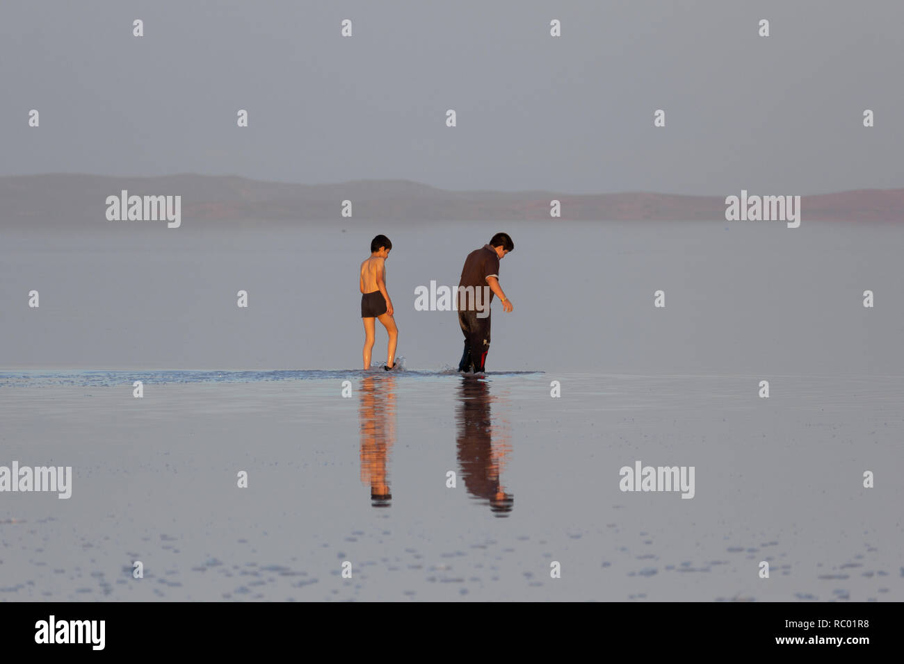 Ein Mann geht mit seinem Sohn in den Salzsee von Urmia-see, West Provinz Aserbaidschan, Iran Stockfoto