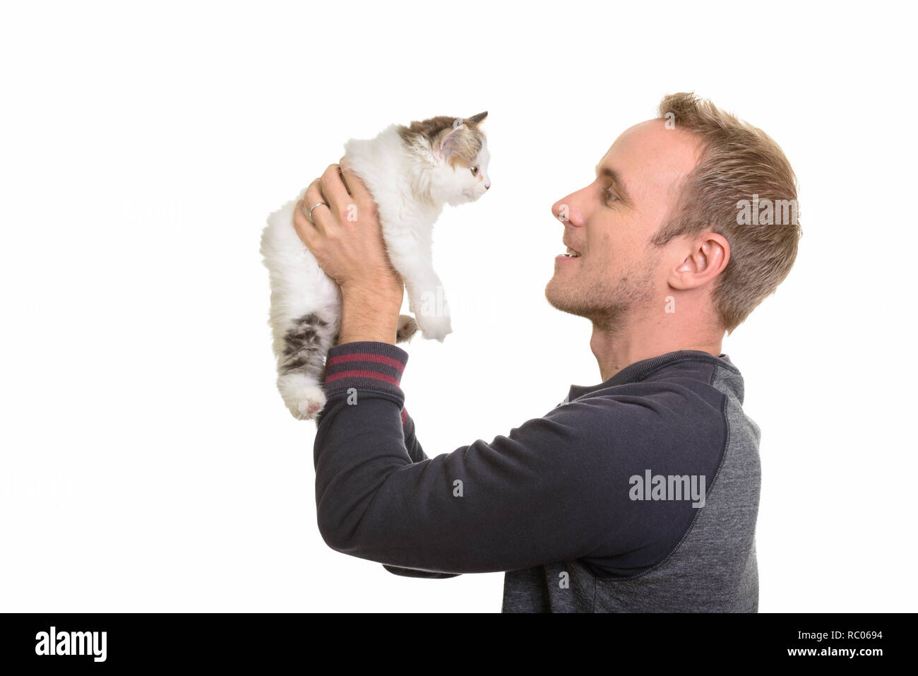 Profil anzeigen von Happy stattlichen kaukasischen Mann hält cute kitten Stockfoto
