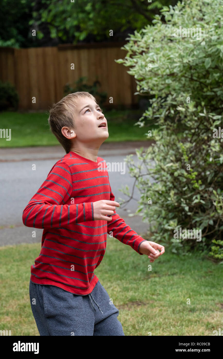 Zehn Jahre alter Junge wartet ein Fußball in seinem Hof zu fangen. (MR) Stockfoto