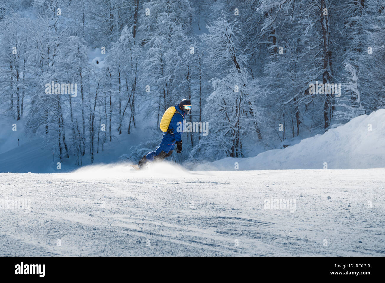 Junger Mann Snowboarder auf der Piste im alpinen Bergwelt. Winter Sport und Erholung, Freizeit Outdoor Aktivitäten. Stockfoto