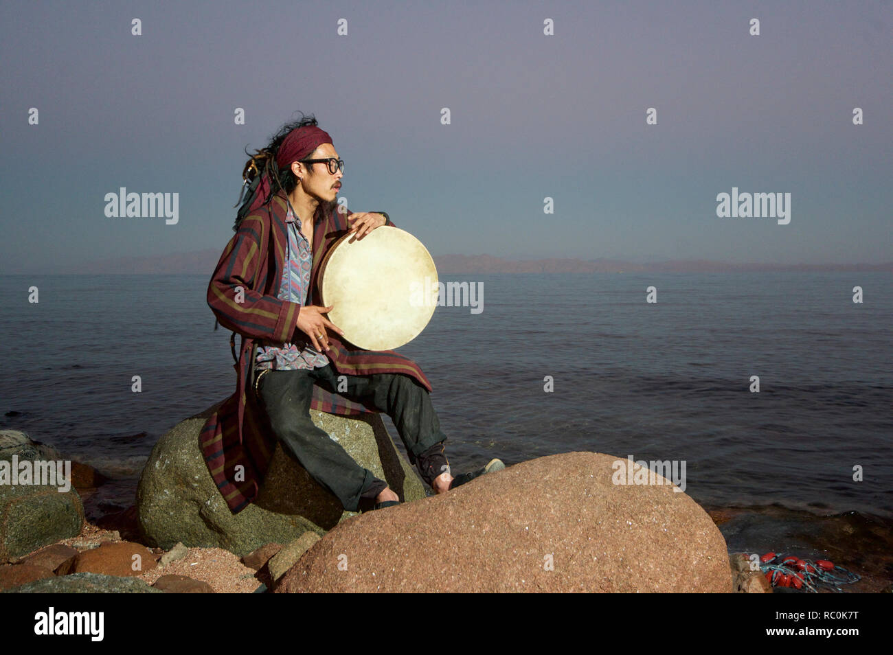 Porträt eines asiatischen Mann spielt Schamanentrommel, Dahab, Ägypten Stockfoto