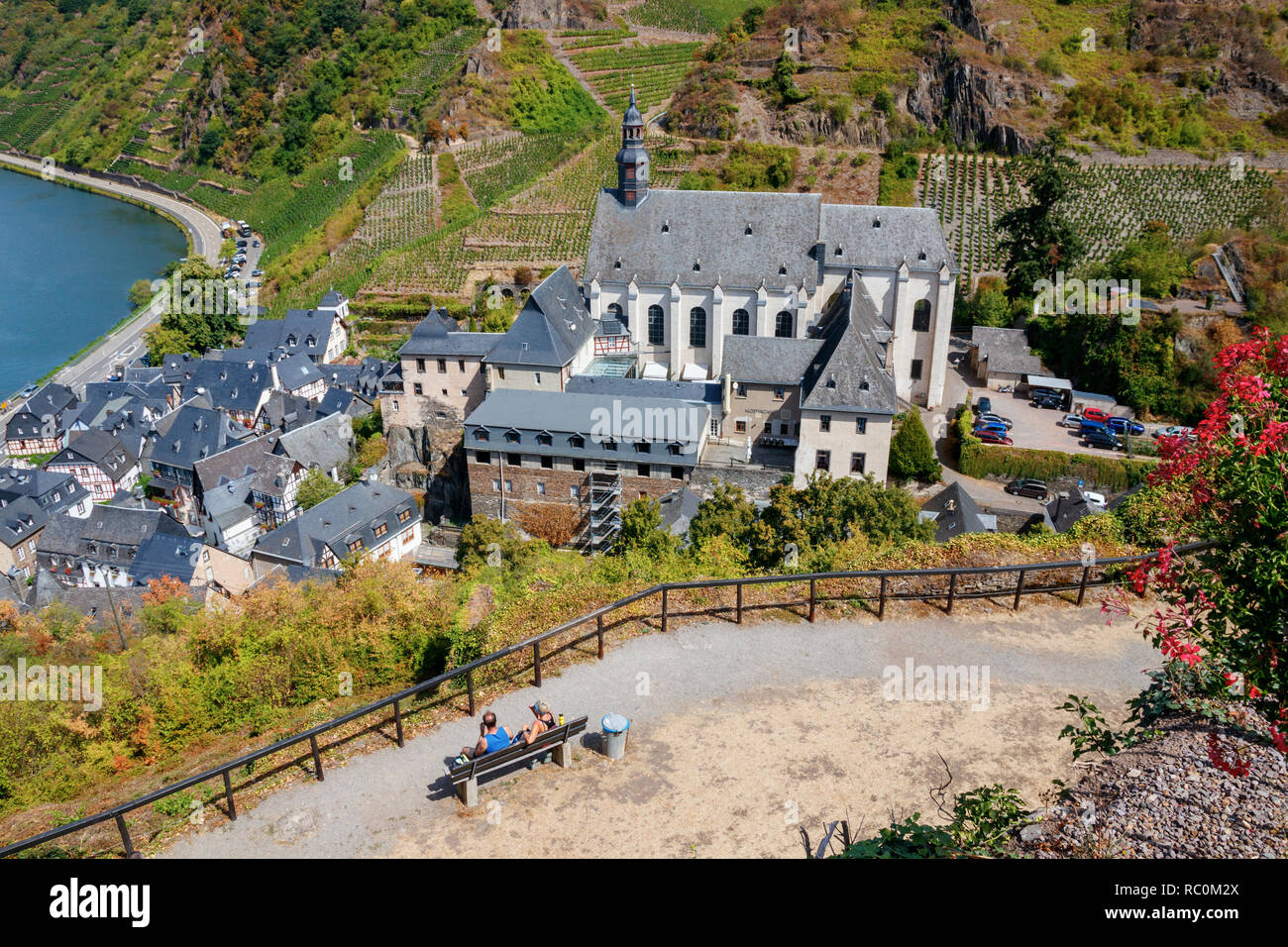 Touristen genießen den Blick auf das Dorf Beilstein an der Mosel mit Klosterkirche die St. Joseph's und die umliegenden Weinberge. Deutschland. Stockfoto