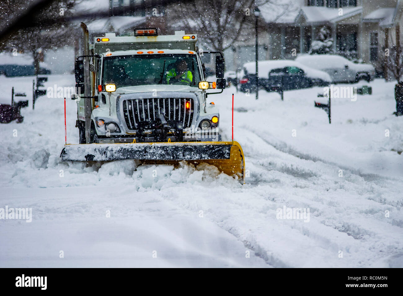 Weisse Truck mit orangefarbenen Warnleuchten Yellow Snow Plow blade Antriebe durch Straßen clearing frisch gefallenen Schnee im Winter Stockfoto