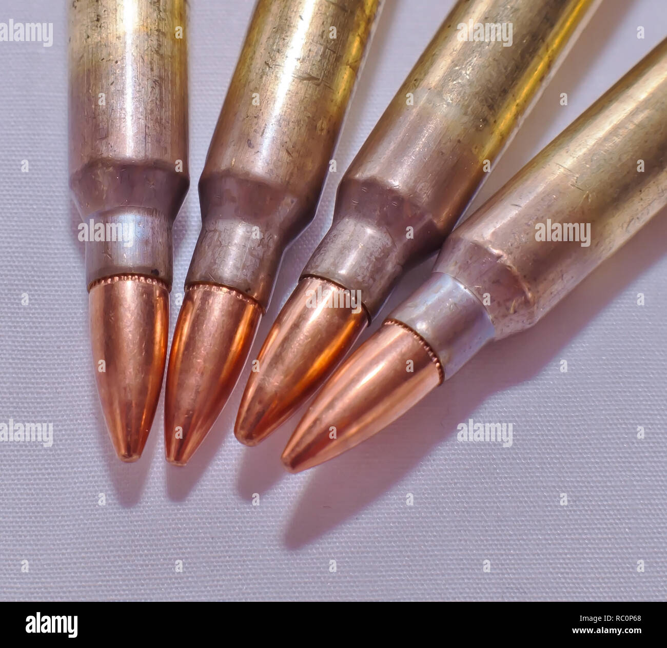 Vier Kaliber .223 Gewehrkugeln auf weißem Hintergrund Stockfoto