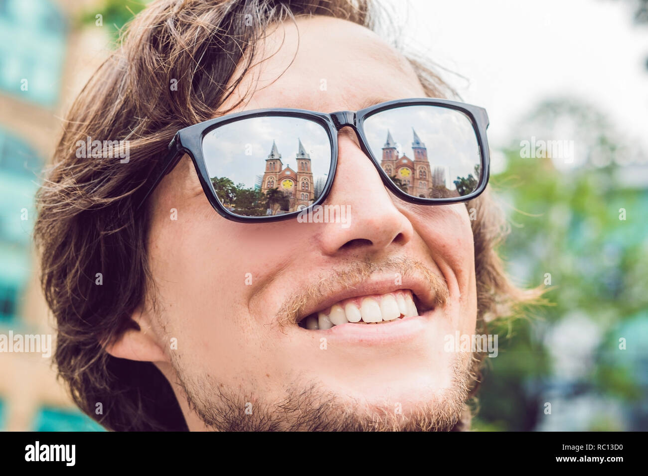Ein Mann schaut auf Notre Dame de Saigon Kathedrale, gebaut 1883 in Ho Chi Minh City, Vietnam. Reflexion in der Brille Stockfoto