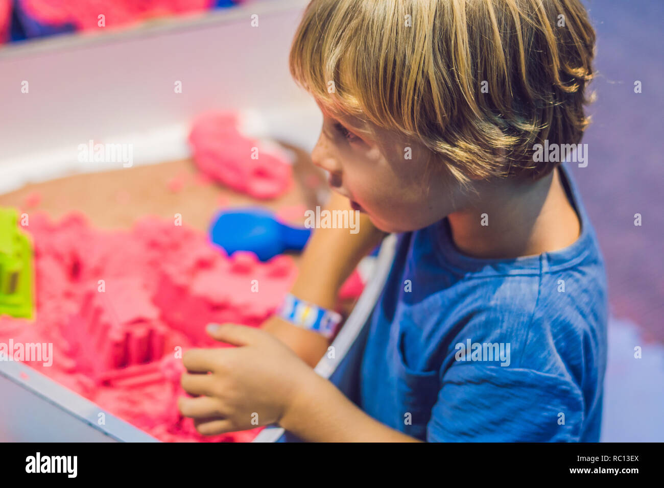 Junge spielt mit kinetischen Sand in die Vorschule. Die Entwicklung der Feinmotorik. Kreativität Spiel Konzept Stockfoto