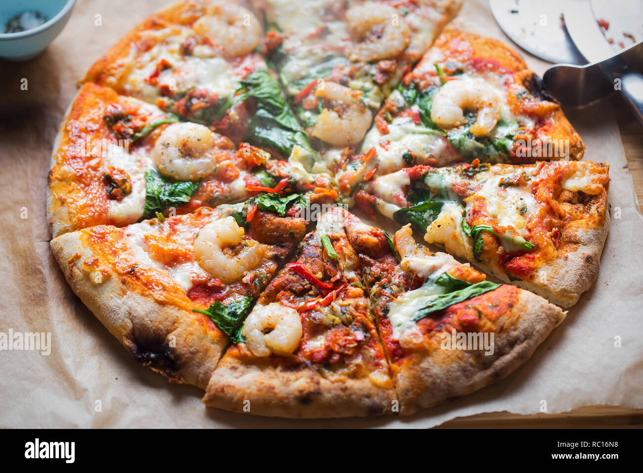 Knoblauch King Prawn Holzofen Pizza mit Spinat & rote Chilischote Stockfoto