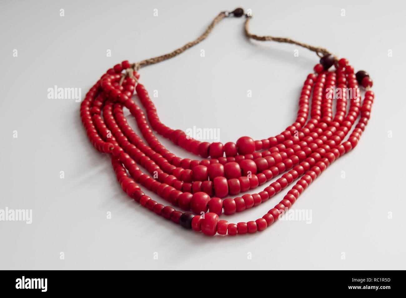 Der rote Perlen liegen auf einem weißen Tisch. Women's Vintage Schmuck. Stockfoto