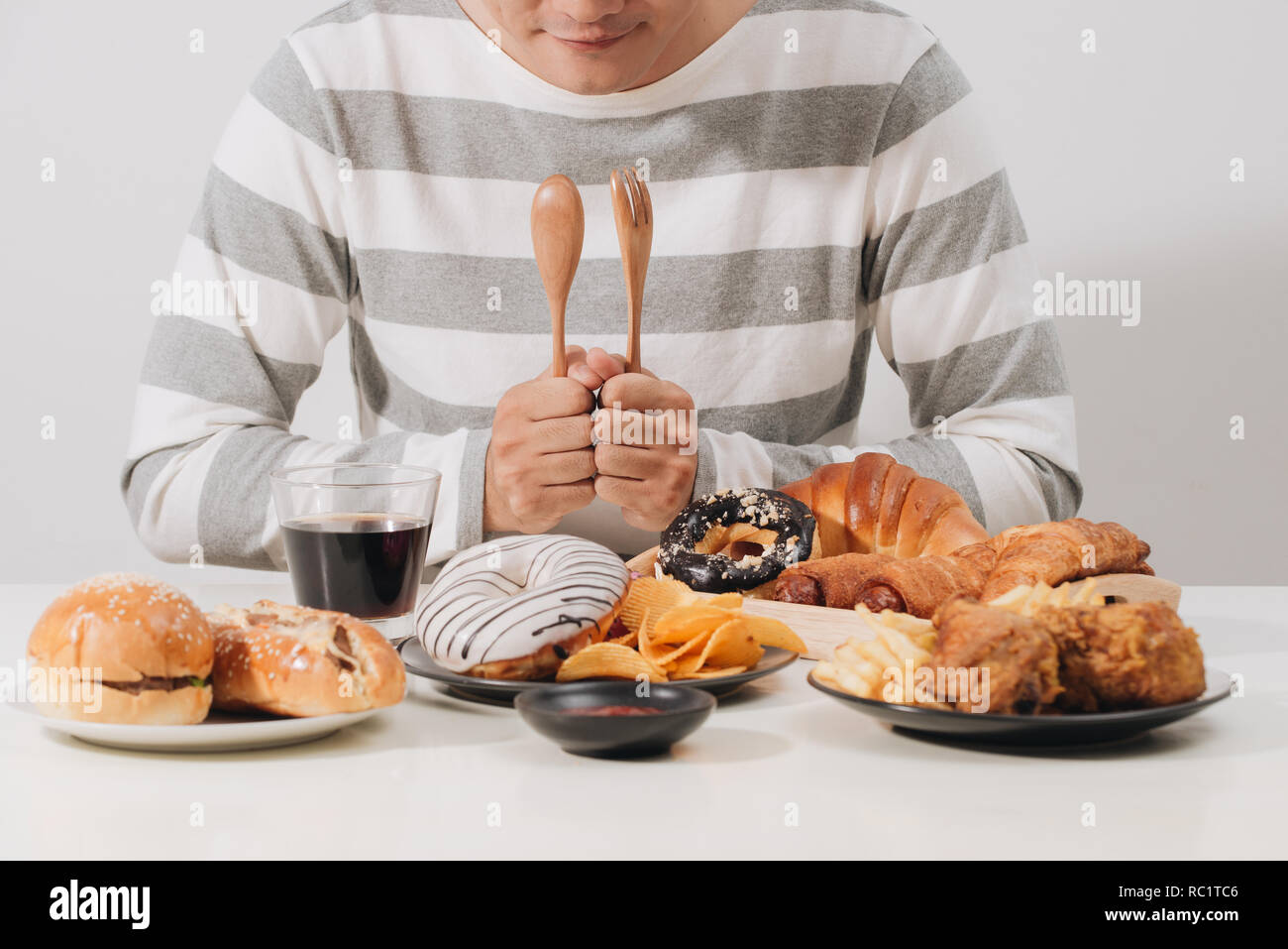 Junger Mann zu Hause auf eine ungesunde Ernährung Stockfoto