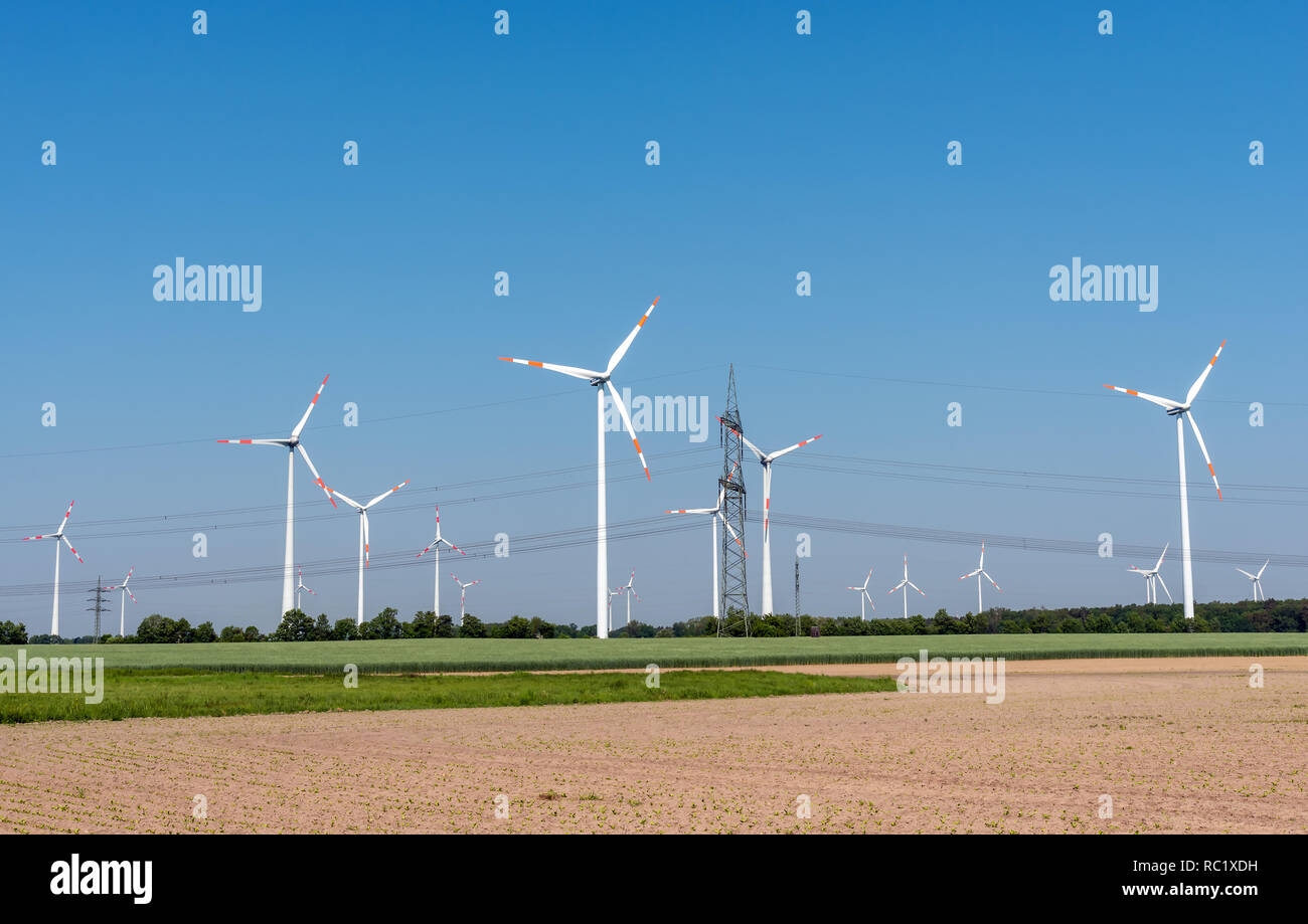 Freileitungen und moderne Windkraftanlagen in den Feldern in Deutschland Stockfoto