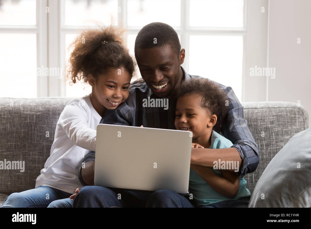 Happy afrikanischen Vater und Kinder mit Laptop tun Familie shop Stockfoto